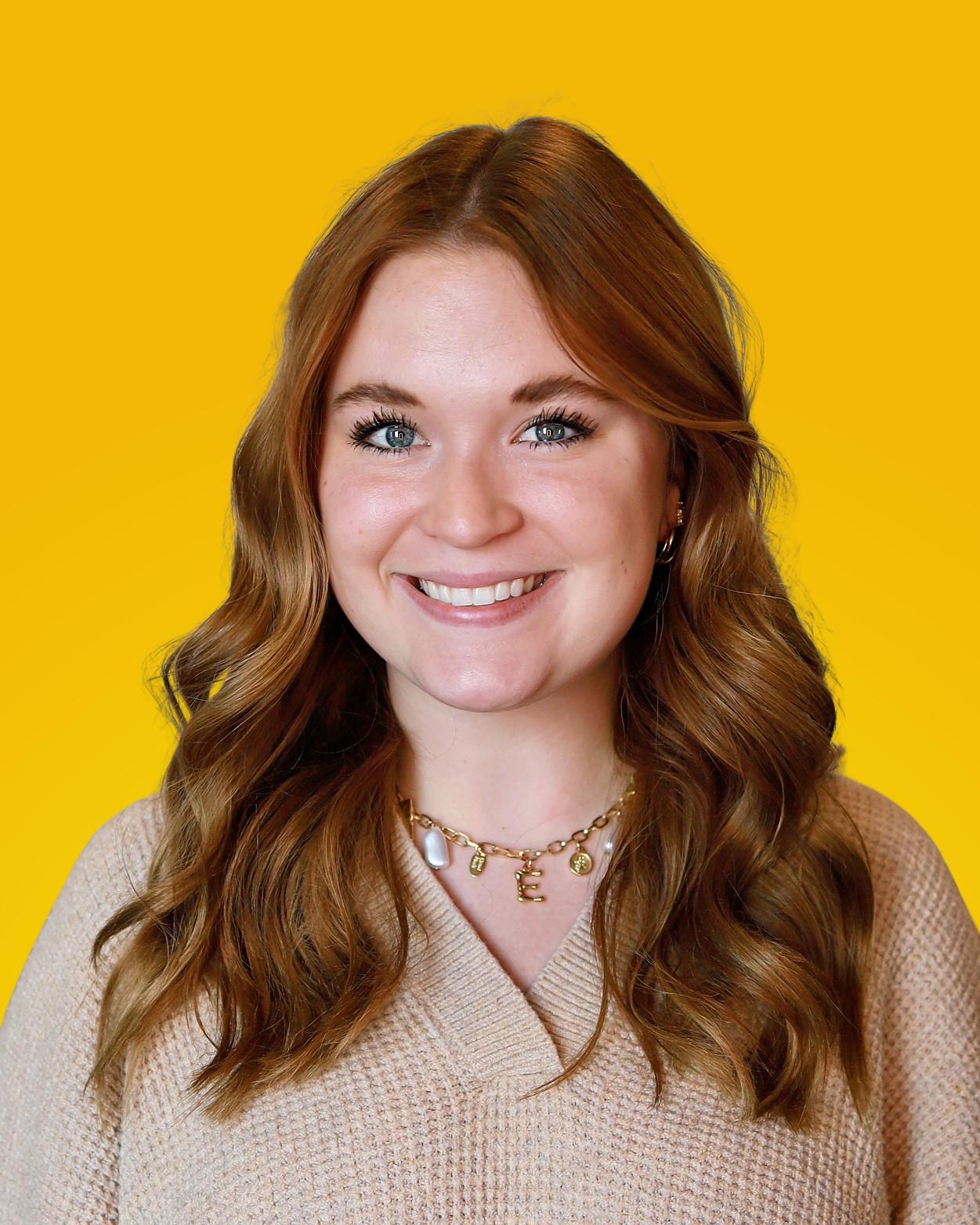 Professional headshot of a woman with long auburn hair